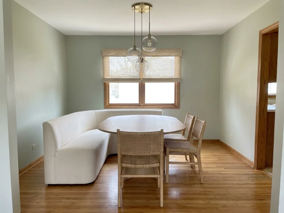 Dining room restyled with an oval table, a soft bench, and a pendant cluster — after