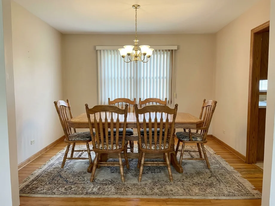 Dining room restyled with an oval table, a soft bench, and a pendant cluster — before