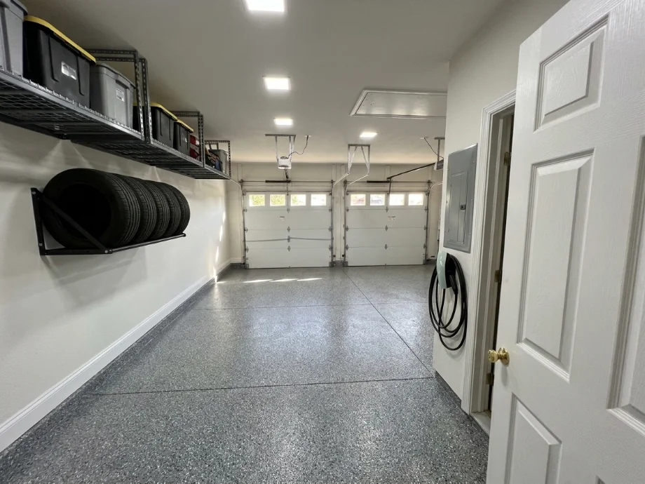 Two-car garage upgraded with an EV charger, overhead racks, and a tire rack — after