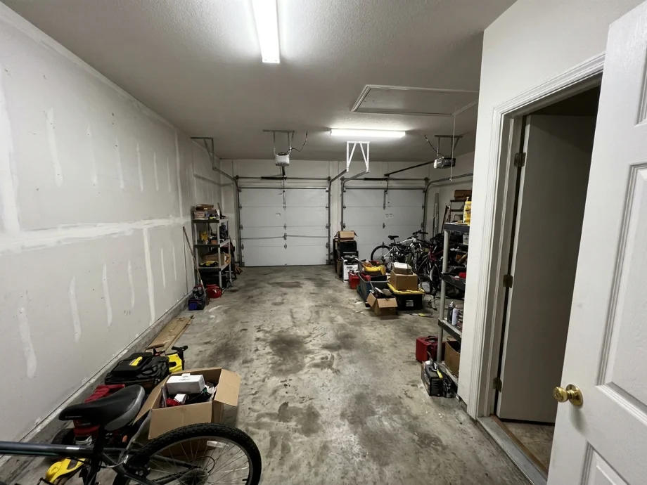 Two-car garage upgraded with an EV charger, overhead racks, and a tire rack — before