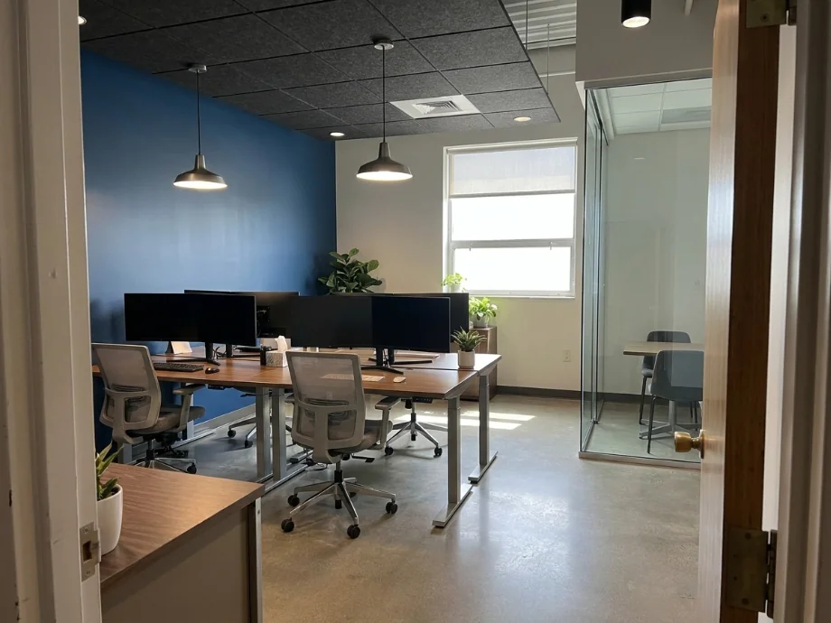 Hybrid office refreshed with hotel desks, a huddle room, and acoustic panels. after AI redesign
