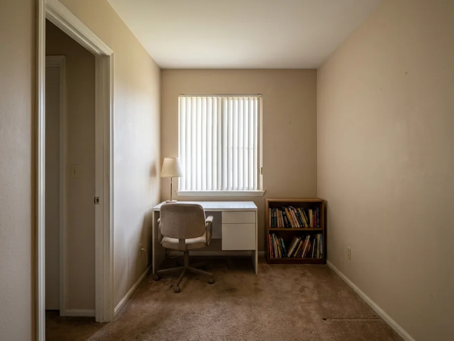 Study room restyled with a long desk, an ergonomic chair, and a task lamp. before AI redesign