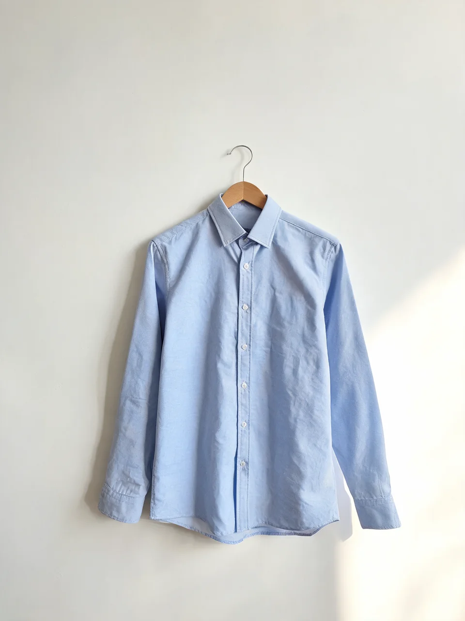 Oxford shirt on a hanger turned into a menswear model product photo before AI redesign
