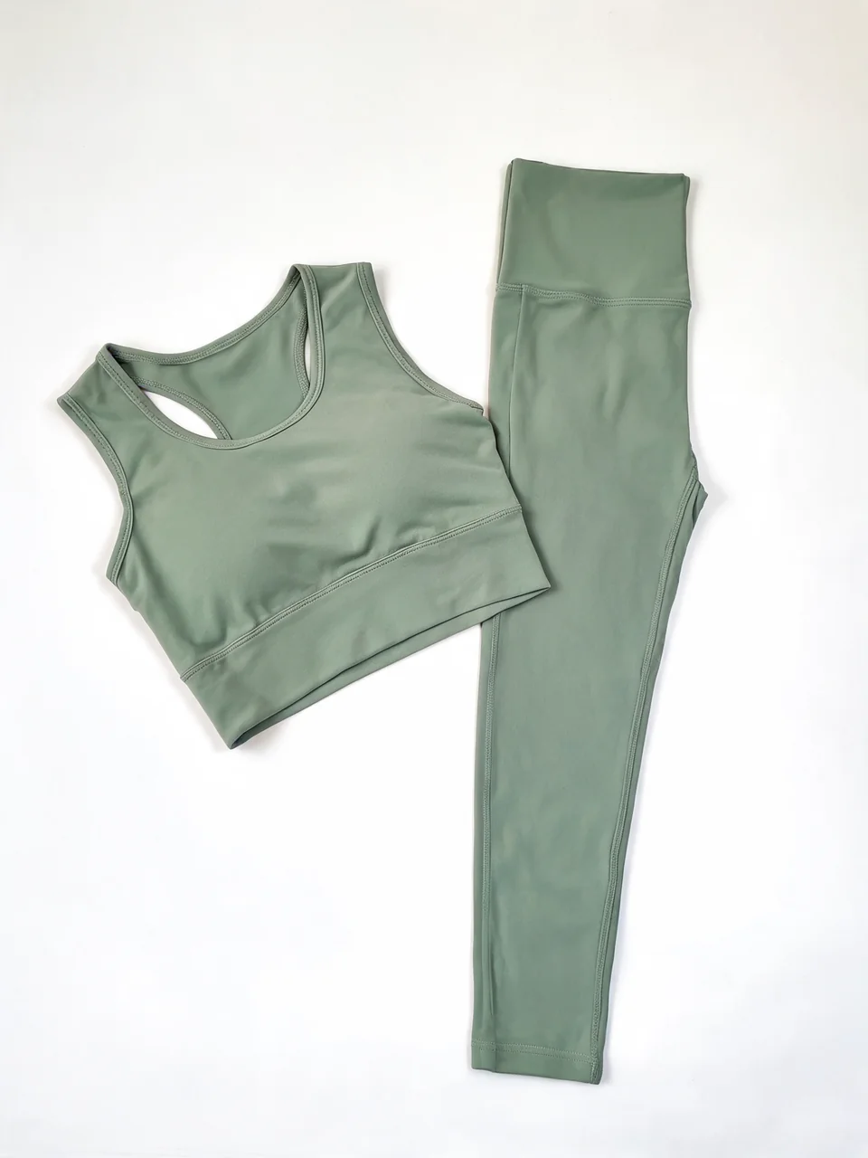 Sage green activewear set flat-lay shown worn by an athletic AI model before AI redesign